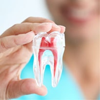 dentist chair and x-ray of teeth roots, which endodontic treatments address